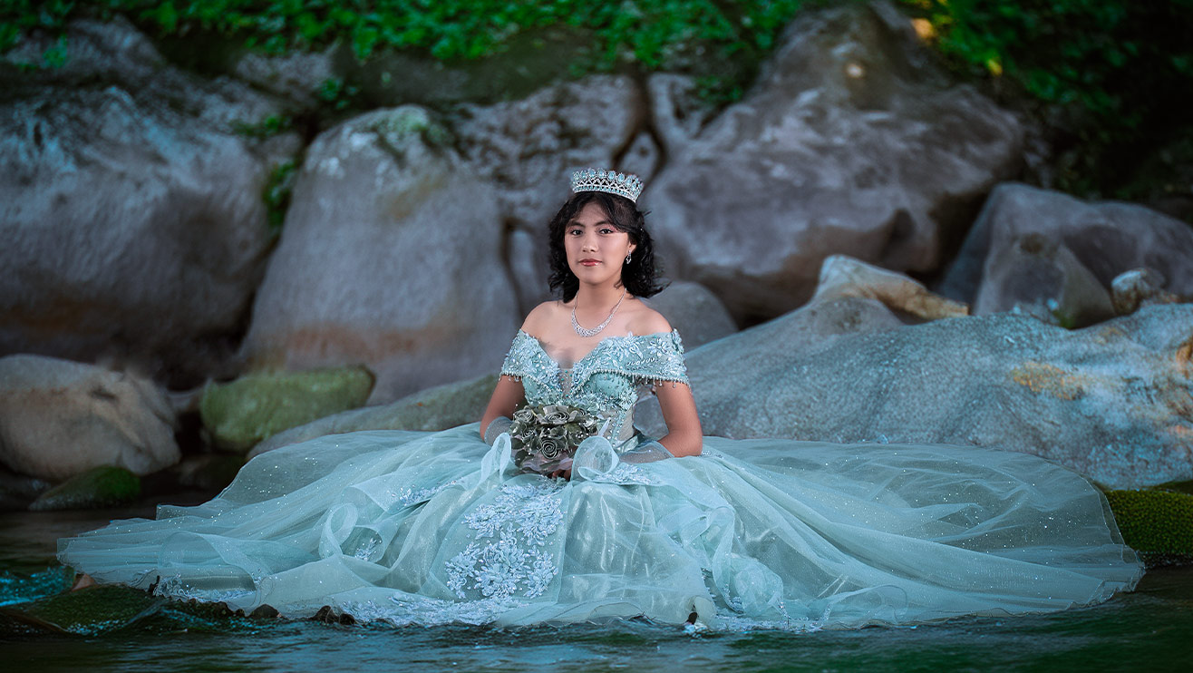 señorita con vetido color aqua sentada y mirandonos